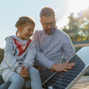 Mann und Kind mit Photovoltaik Panel
